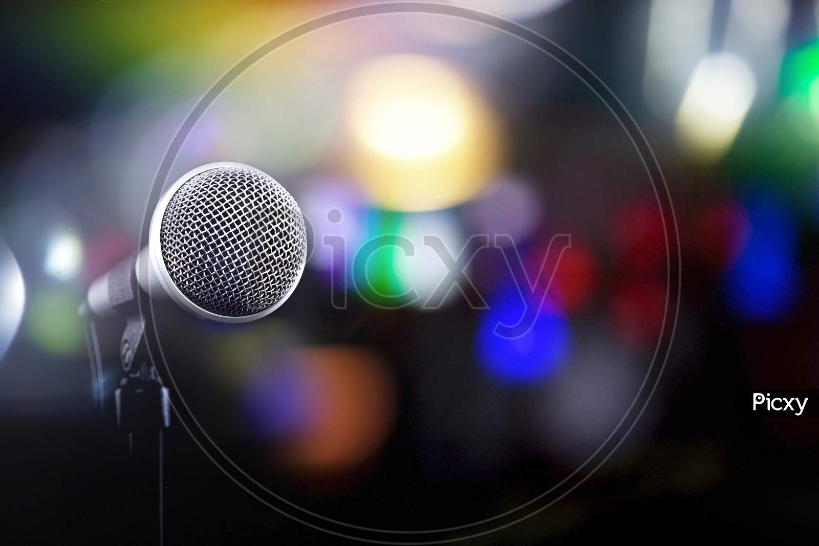 Microphone On A Black Background With Colorful Lights And Flares