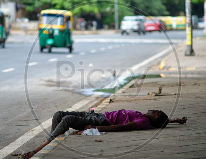 Poor Homeless Man Sleeping On Sidewalk In New Delhi, India