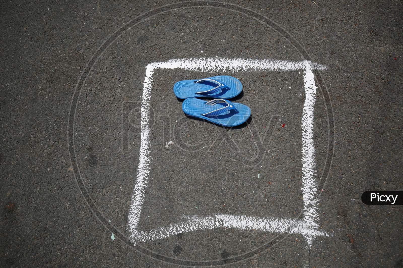 A pair of slippers is left to secure a spot in a box drawn on a street to maintain social distancing during the nationwide lockdown to stop the spread of Coronavirus (COVID-19) in Bangalore, India, May 02, 2020.
