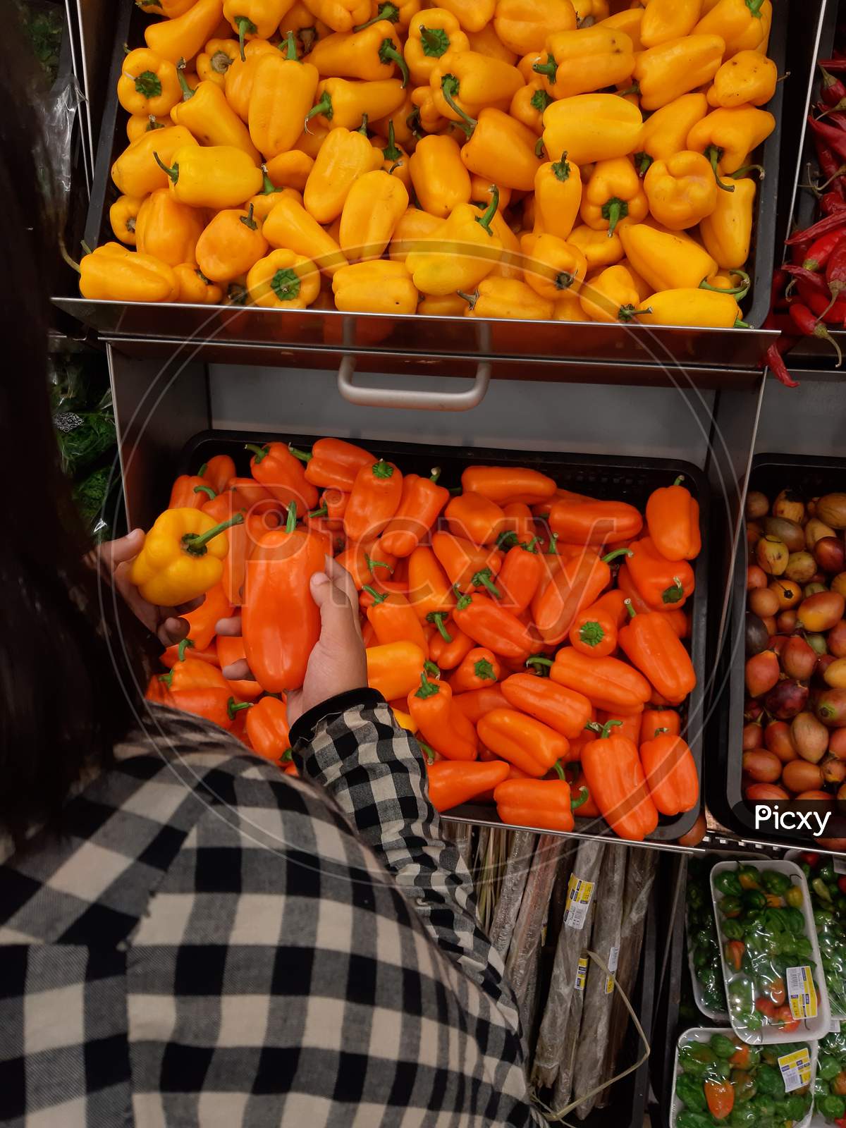 girl picking vegetables from supermarket