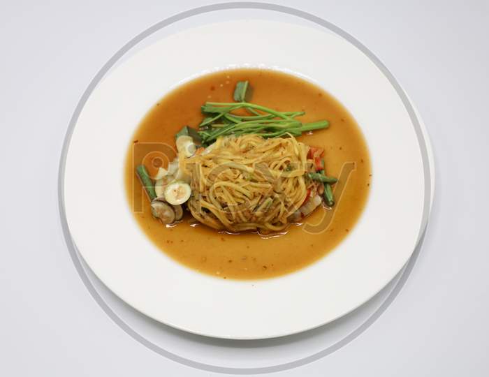 Asian vegetarian food udon noodles with Beijing cabbage, carrots, green beans, bell pepper, onions  served in a Plate isolated with White Background