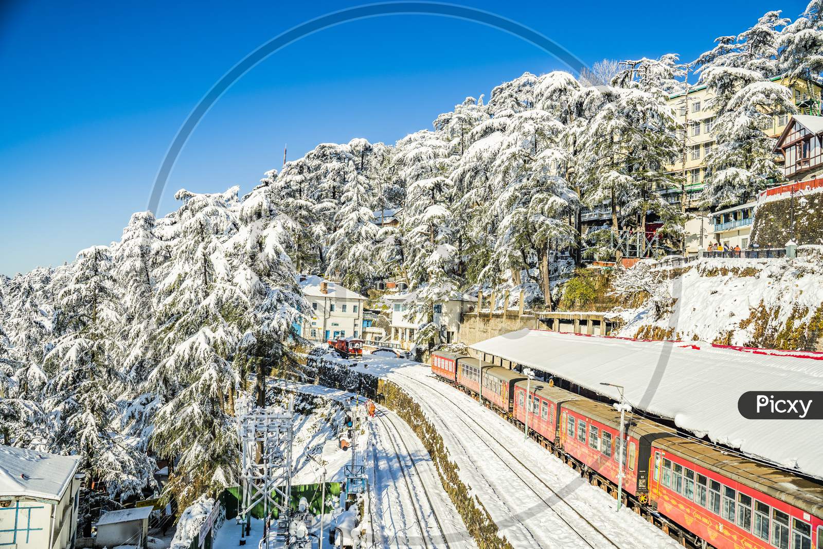 Snowfall View moving train on mountain slopes, beautiful view, one side mountain, one side valley. Toy train from Shimla to Kalka