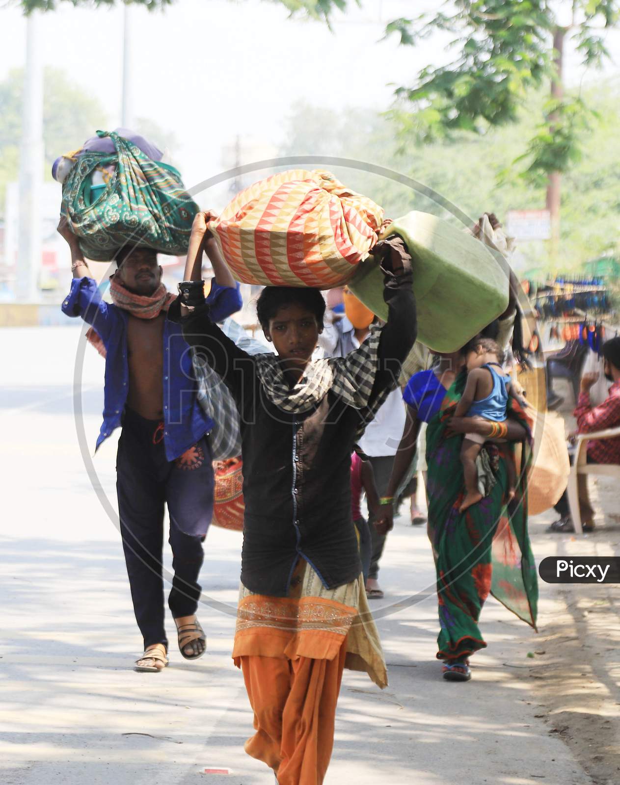 Migrant labourers carry goods as the walk on the road during an extended nationwide lockdown to slow the spread of the coronavirus disease, in Prayagraj, May 4, 2020.