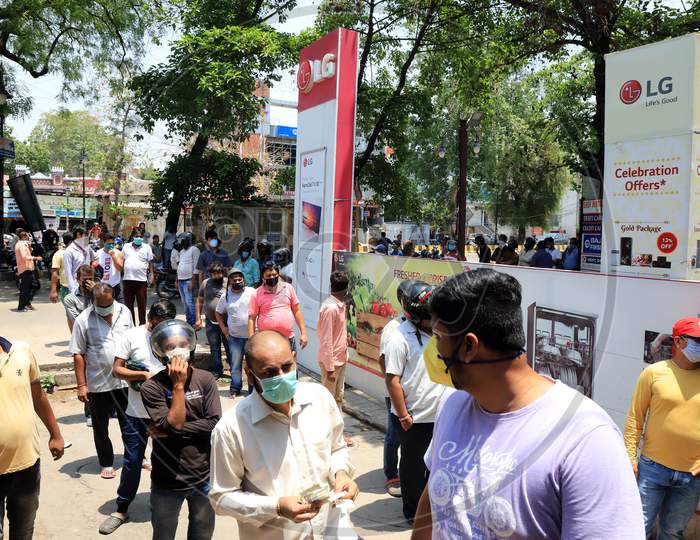 People stand in a queue to buy liquor outside a wine shop during an extended nationwide lockdown to slow the spread of the Coronavirus disease or COVID-19, in Prayagraj on May 4, 2020.