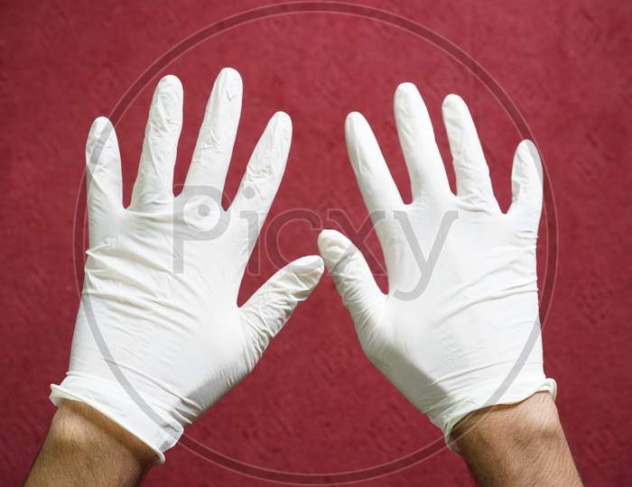 White medical gloves worn by a man.