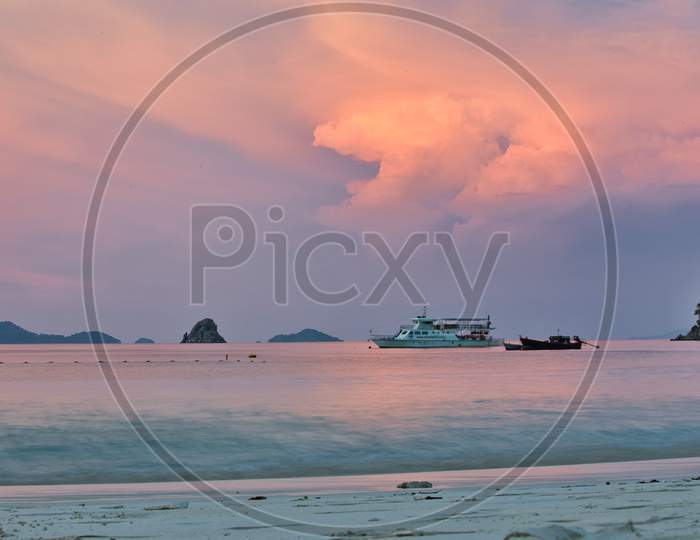 A ship sailing in an Ocean with Sunset in the Background