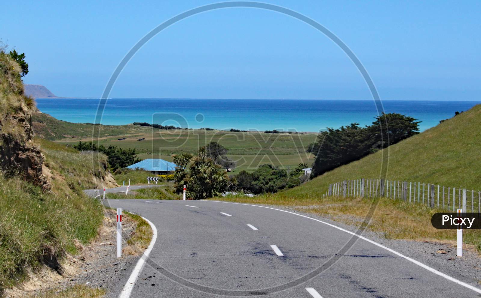 Winding Road Leads Down To The Sea In New Zealand.