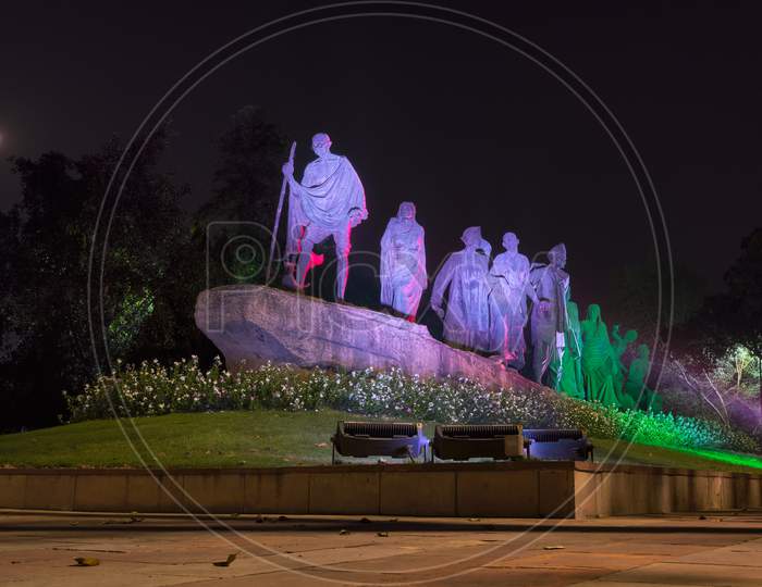 Dandi March Statue Illuminated At Night, Commemorating The Salt March Of 1930, With Gandhi And His Followers In Peaceful Protest In New Delhi, India