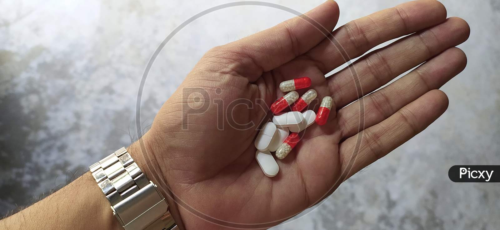 Tablets and capsules in hand close up shot