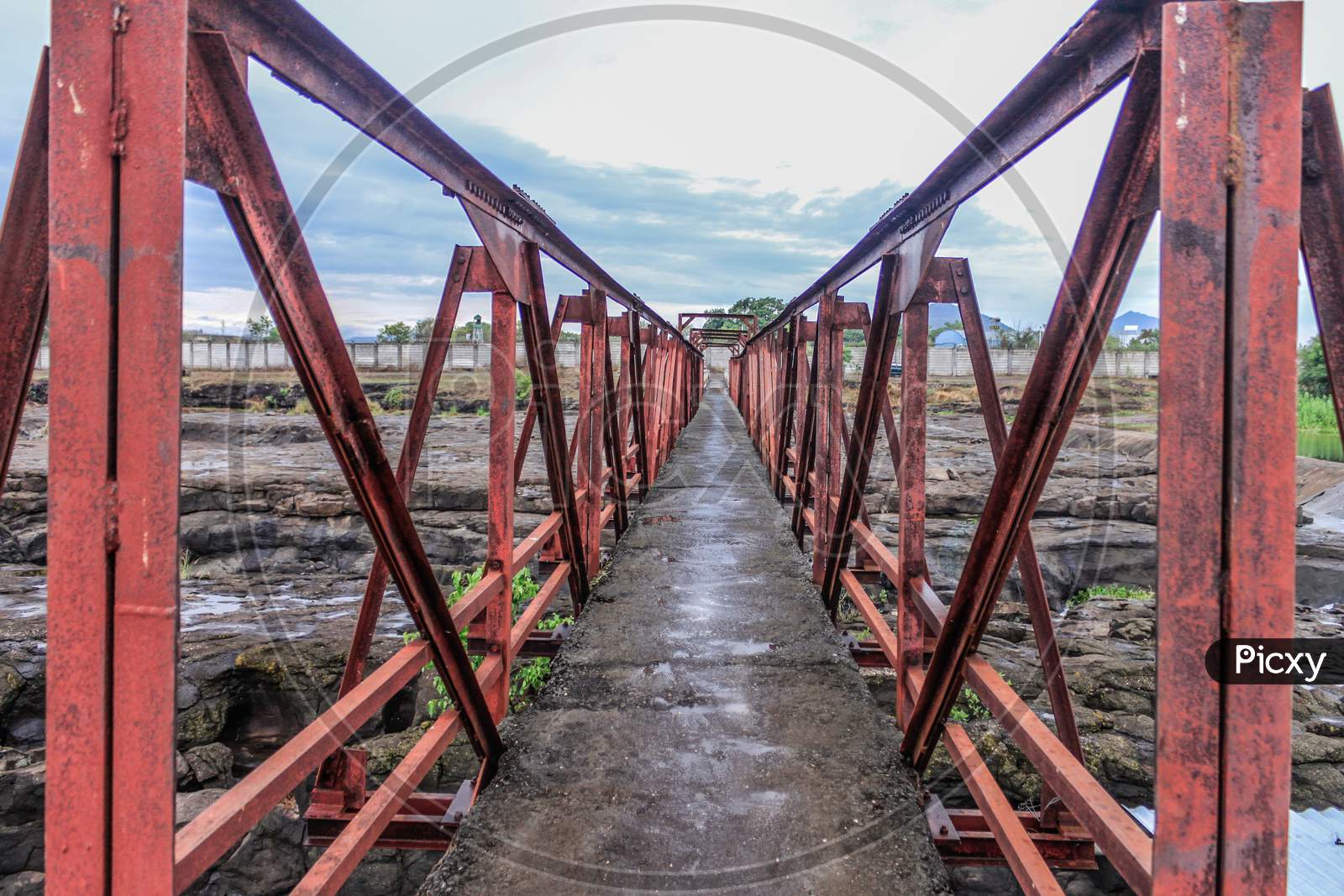 steel truss bridge for pedestrian crossing on a river in rural Indian village