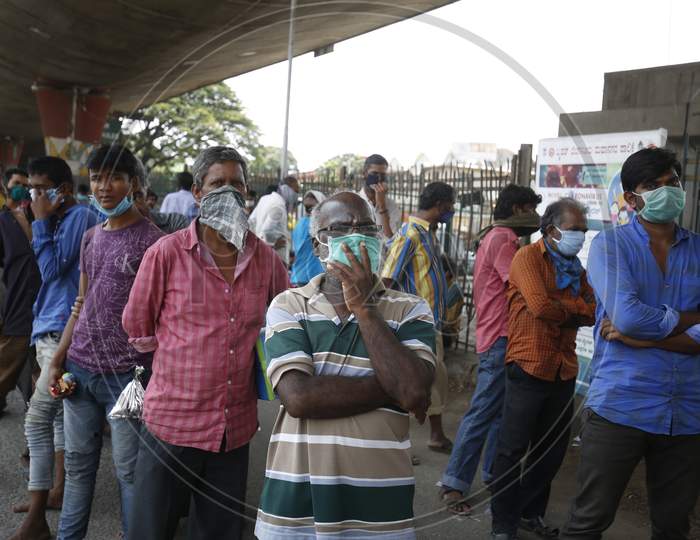 Homeless people wait for food to be distributed on a street during the nationwide lockdown to stop the spread of Coronavirus (COVID-19) in Bangalore, India, May 02, 2020.