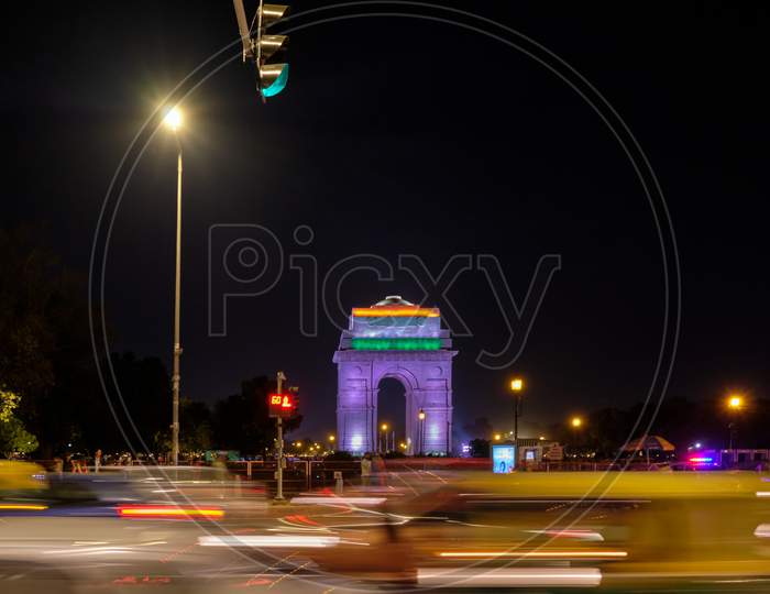 Night View Of The Illuminated India Gate War Memorial And Traffic On The India Gate Circle Road In New Delhi, India