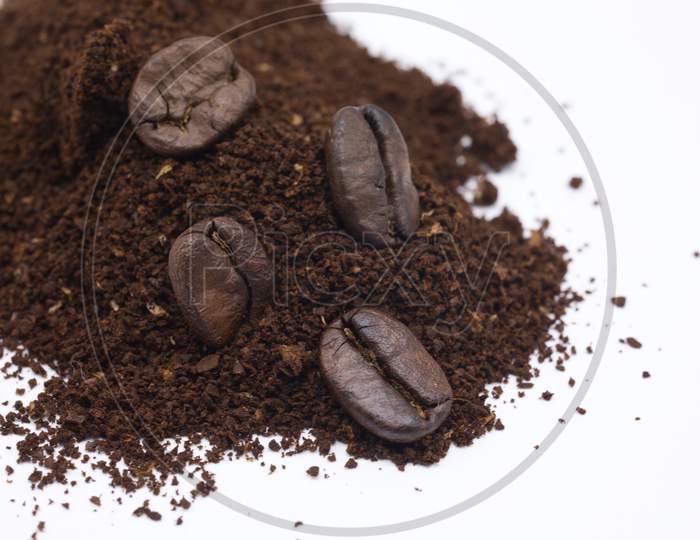 Close up shot of Coffee Beans with Coffee Powder on White Background