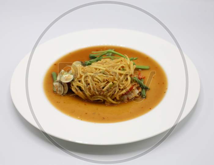 Asian vegetarian food udon noodles with Beijing cabbage, carrots, green beans, bell pepper, onions served in a Plate isolated with White Background