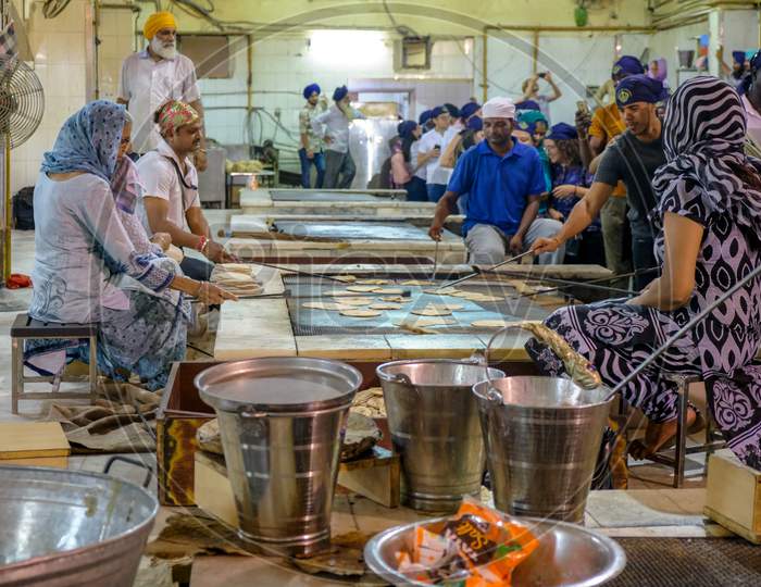 Volunteers Preparing Free Food For Visitors In The Gurdwara Community Kitchen (Langar Hall) Of Sri Bangla Sahib Gurudwara Sikh Temple, New Delhi, India