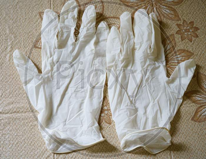 White medical gloves on a floral surface