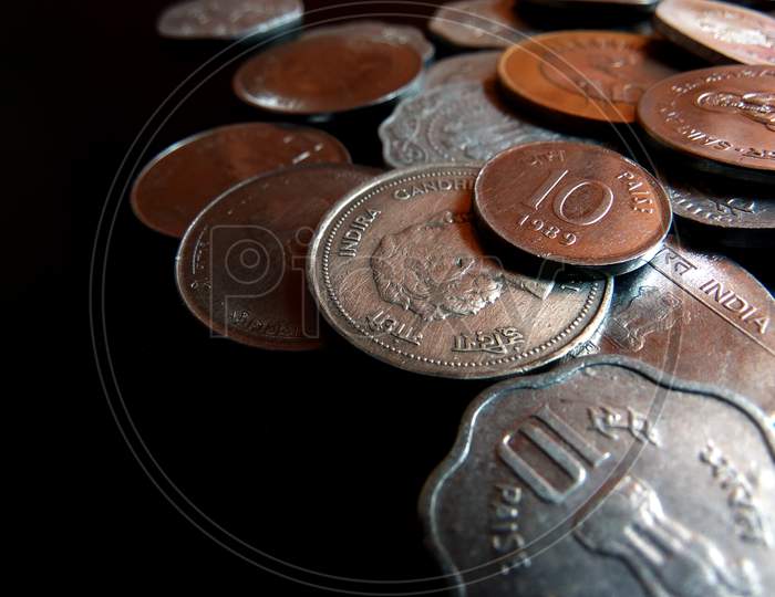 Closeup  shot of coins displaying Indian currency of various values on a dark background