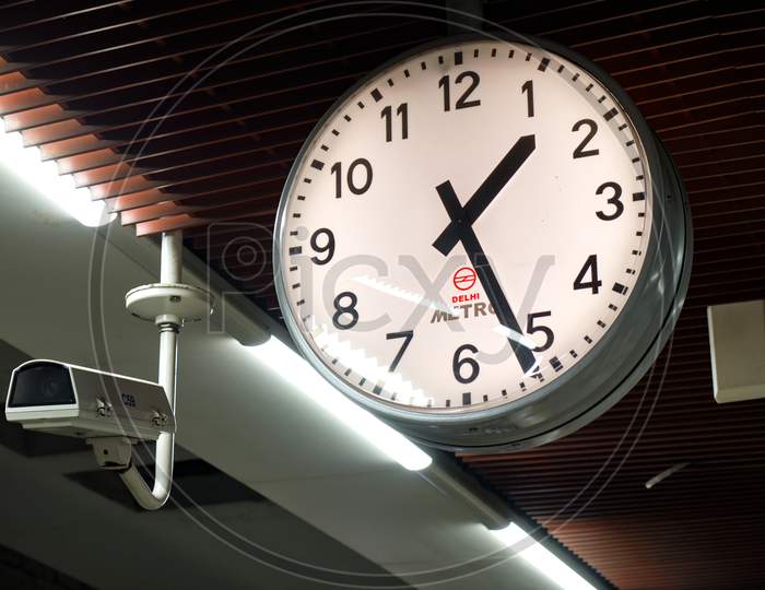 Clock And A Security Camera At Delhi Metro Subway Station Platform