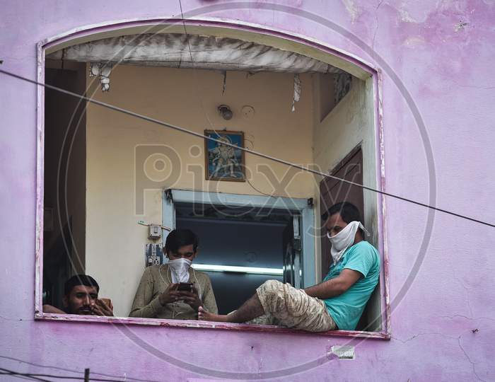 People Look At Their Mobile Phones, As They Spend Time At The Balcony Of Their House During The Nationwide Lockdown, Imposed In The Wake Of Coronavirus Pandemic, In Vijayawada.
