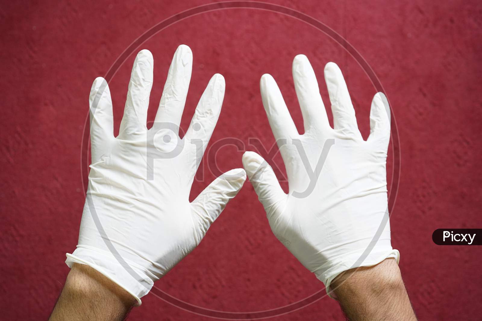 White medical gloves worn by a man.