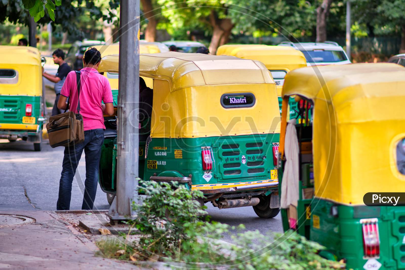 Man Paying The Fare To The Tuk Tuk Driver In The Street In New Delhi, India