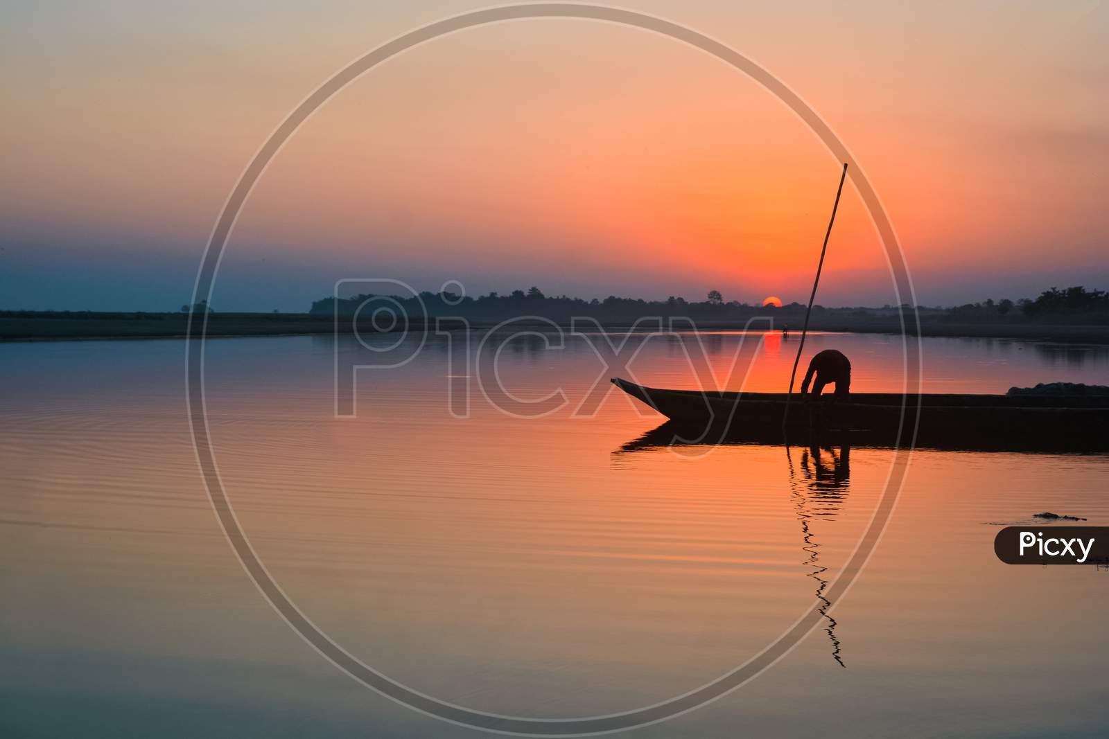 A fishermen with his boat on the River Brahmaputra at Sunset.