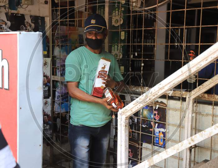A man carrying liquor coming out of wine shop during an extended nationwide lockdown to slow the spread of the coronavirus disease or COVID-19 in prayagraj, May 4, 2020.
