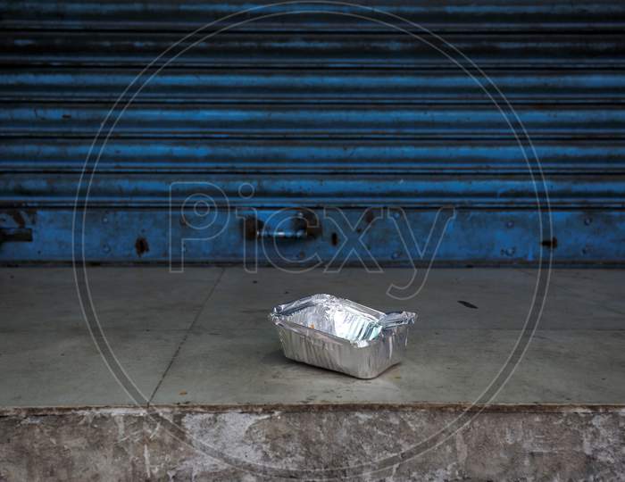 A box with partially eaten food is seen outside a shuttered shop during the nationwide lockdown to stop the spread of Coronavirus (COVID-19) in Bangalore, India, May 01, 2020.