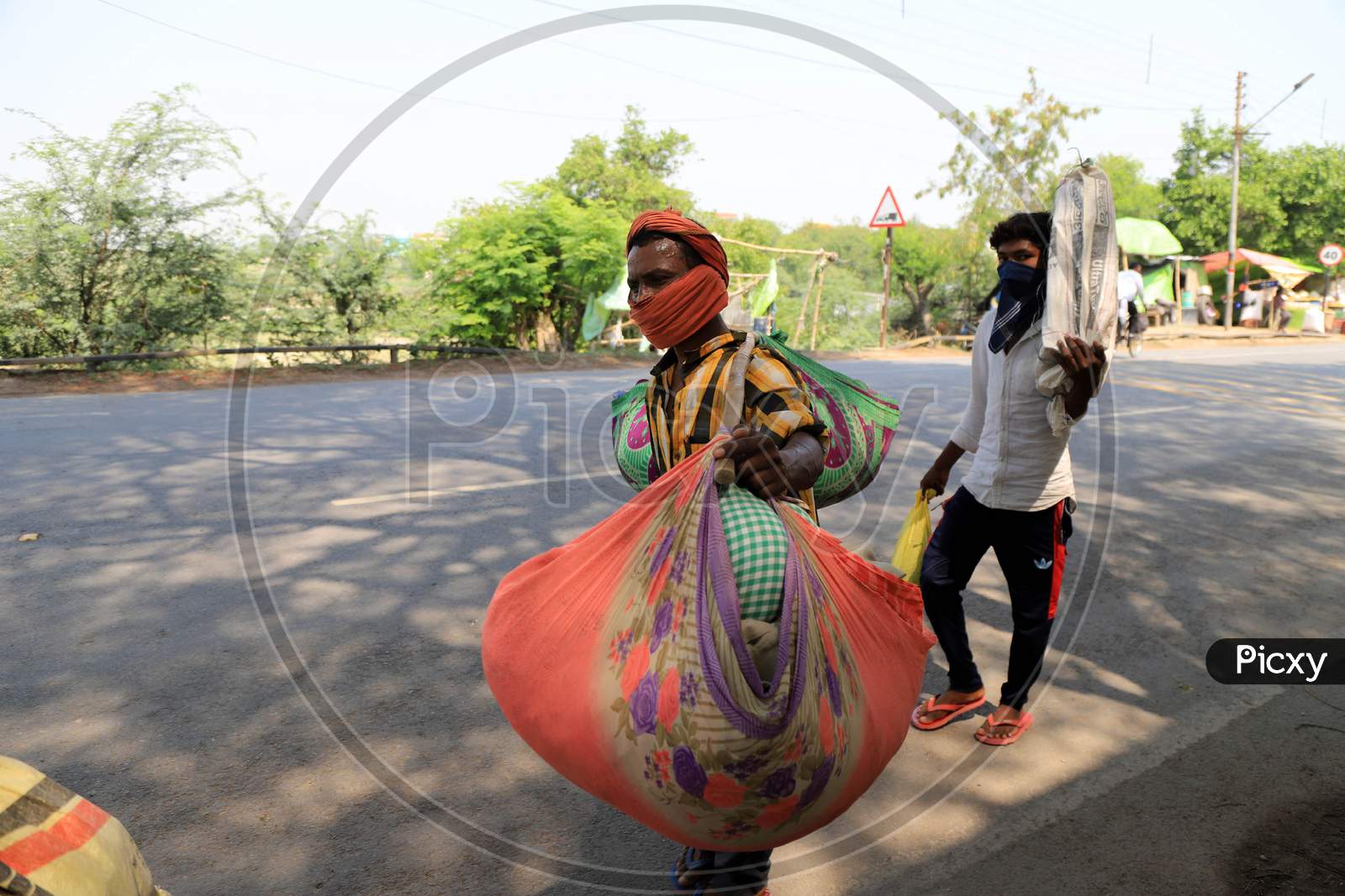 Migrant labourers carry goods as the walk on the road during an extended nationwide lockdown to slow the spread of the coronavirus disease, in Prayagraj, May 4, 2020.