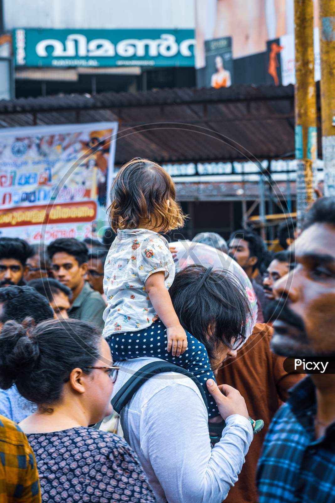 street photo of a foreign family during thrissur pooram