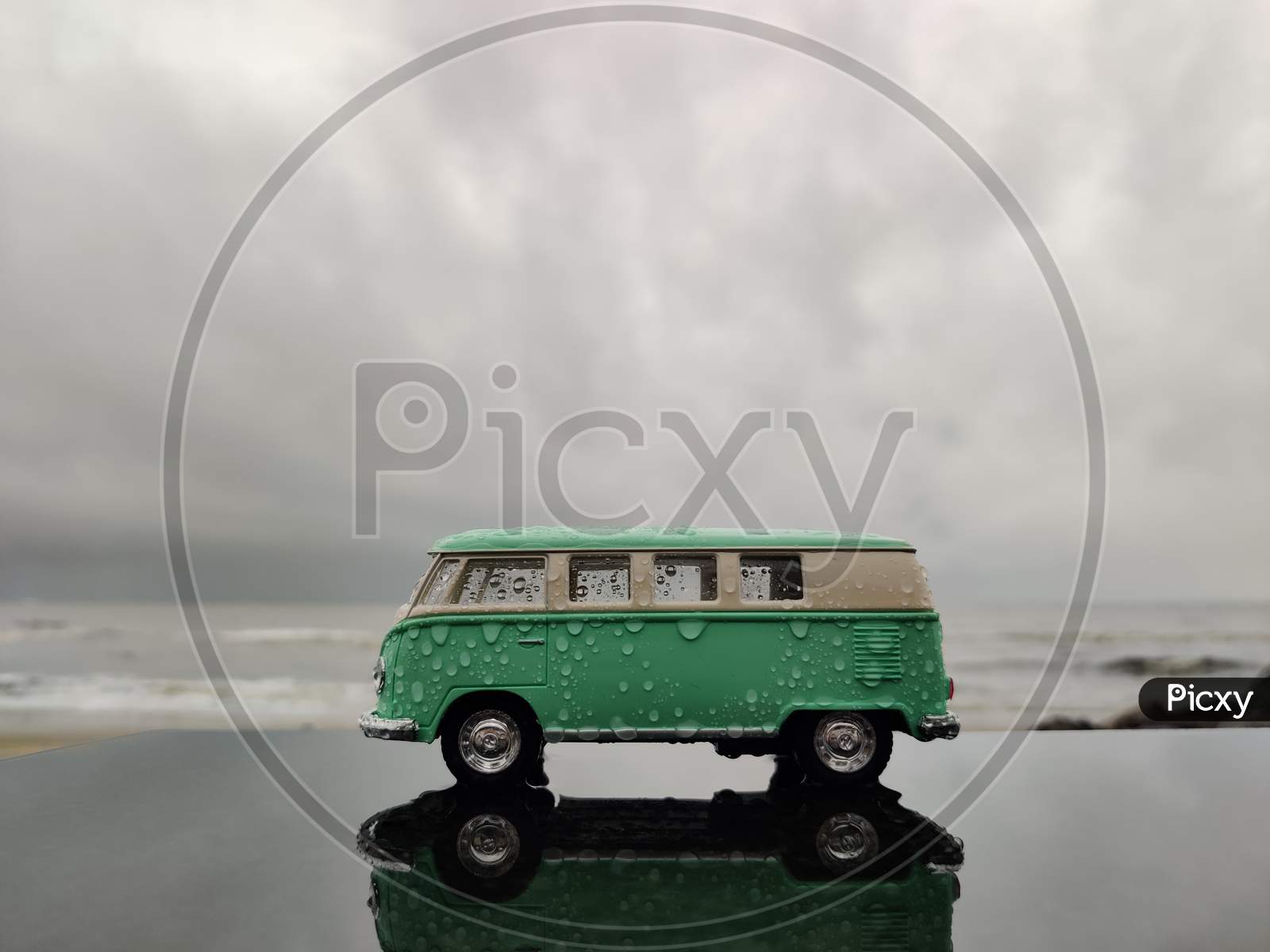 rainy moody image of vintage toy van with beach background