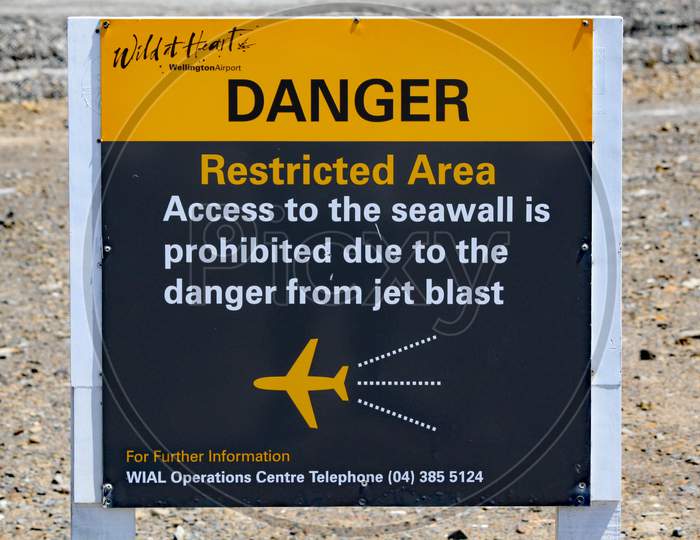 A Sign At The End Of The Airport Runway At Wellington, New Zealand, Warning Of The Dangers Of Jet Blast And Standing Too Close.