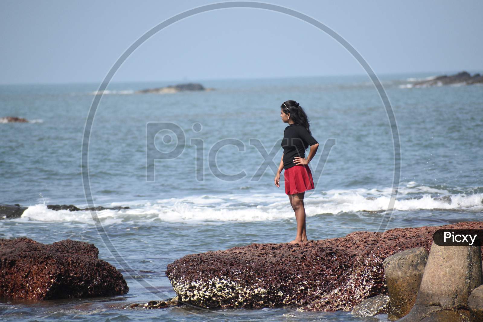 Red and black dressed women in the Goa beach.