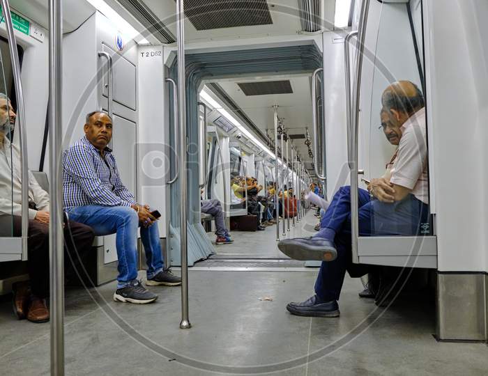 People Sitting In A Train Carriage Of Delhi Metro System