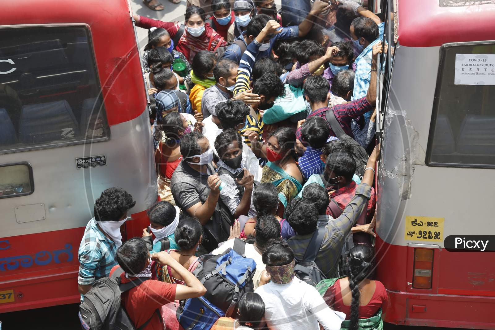 People attempt to board public transport buses during the nationwide lockdown to stop the spread of Coronavirus (COVID-19) in Bangalore, India, May 03, 2020.