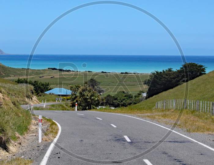 Winding Road Leads Down To The Sea In New Zealand.