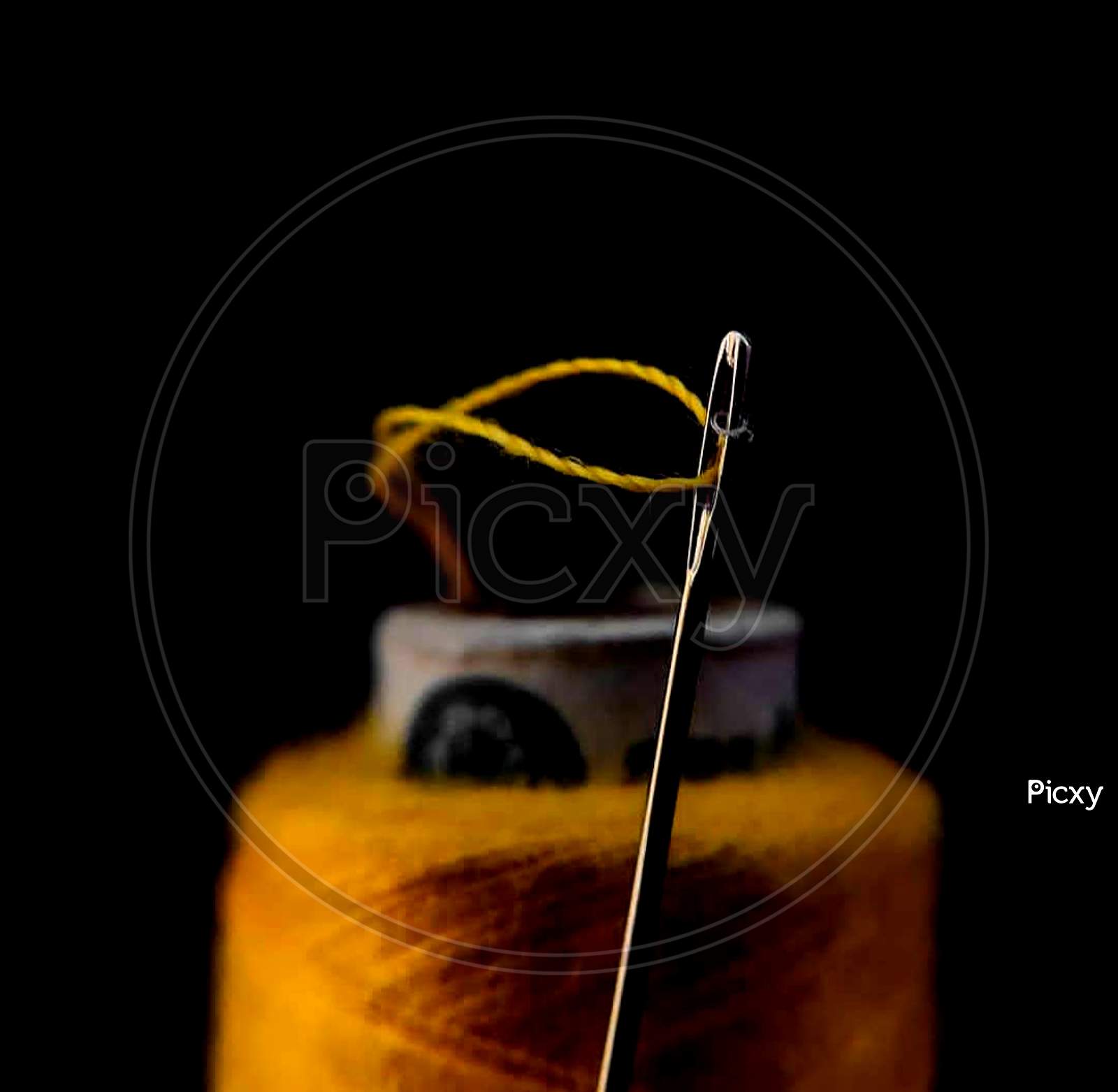 Needle and yellow thread focused on needle