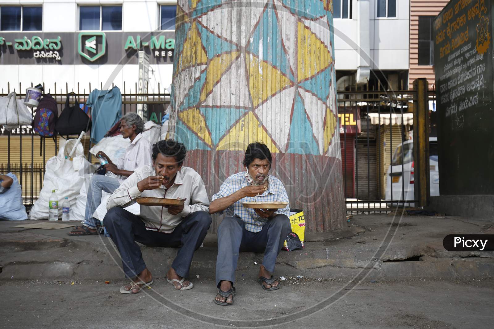 Homeless men eat a free meal provided to them during the nationwide lockdown to stop the spread of Coronavirus (COVID-19) in Bangalore, India, May 03, 2020.