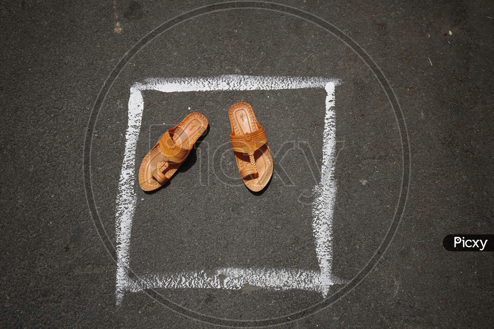 A pair of slippers is left to secure a spot in a box drawn on a street to maintain social distancing during the nationwide lockdown to stop the spread of Coronavirus (COVID-19) in Bangalore, India, May 02, 2020.
