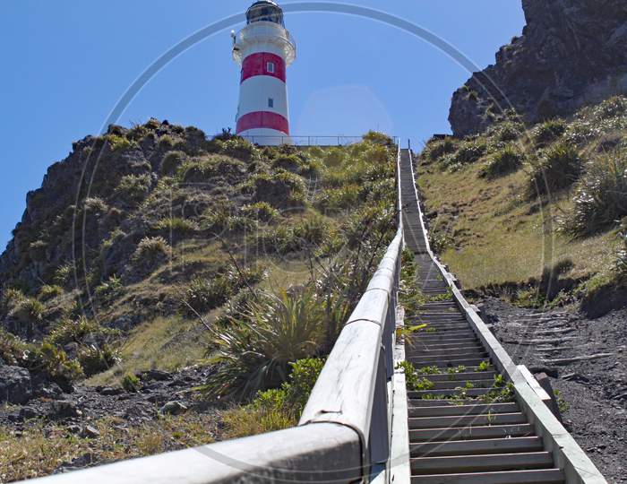 250 Steps Lead Up To The Red And White Striped Lighthouse At Cape Palliser On North Island, New Zealand. The Lighthouse Was Built In 1897 And Was Originally Fueled By Oil.