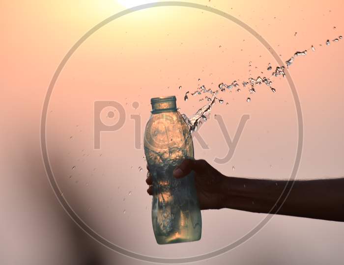 splash water from bottle with sunset background
