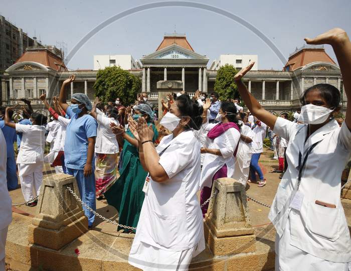 Nurses and hospital staff of Victoria Hospital cheer as an Indian Air Force (IAF) helicopter showers flowers on them during the nationwide lockdown to stop the spread of Coronavirus (COVID-19) in Bangalore, India, May 03, 2020.