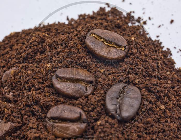 Close up shot of Coffee Beans with Coffee Powder on White Background