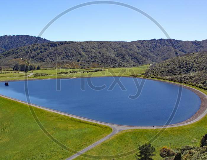 Clear Blue Reservoir Set In The Hills In North Island, New Zealand