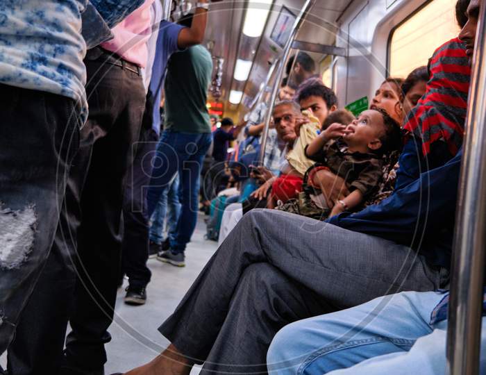 People Sitting In A Train Carriage Of Delhi Metro System