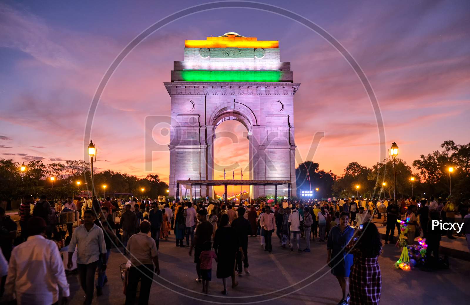 Tourists Visit The Illuminated India Gate War Memorial During Colorful Sunset, New Delhi, India
