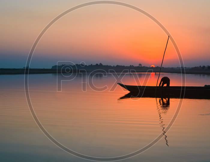 A fishermen with his boat on the River Brahmaputra at Sunset.