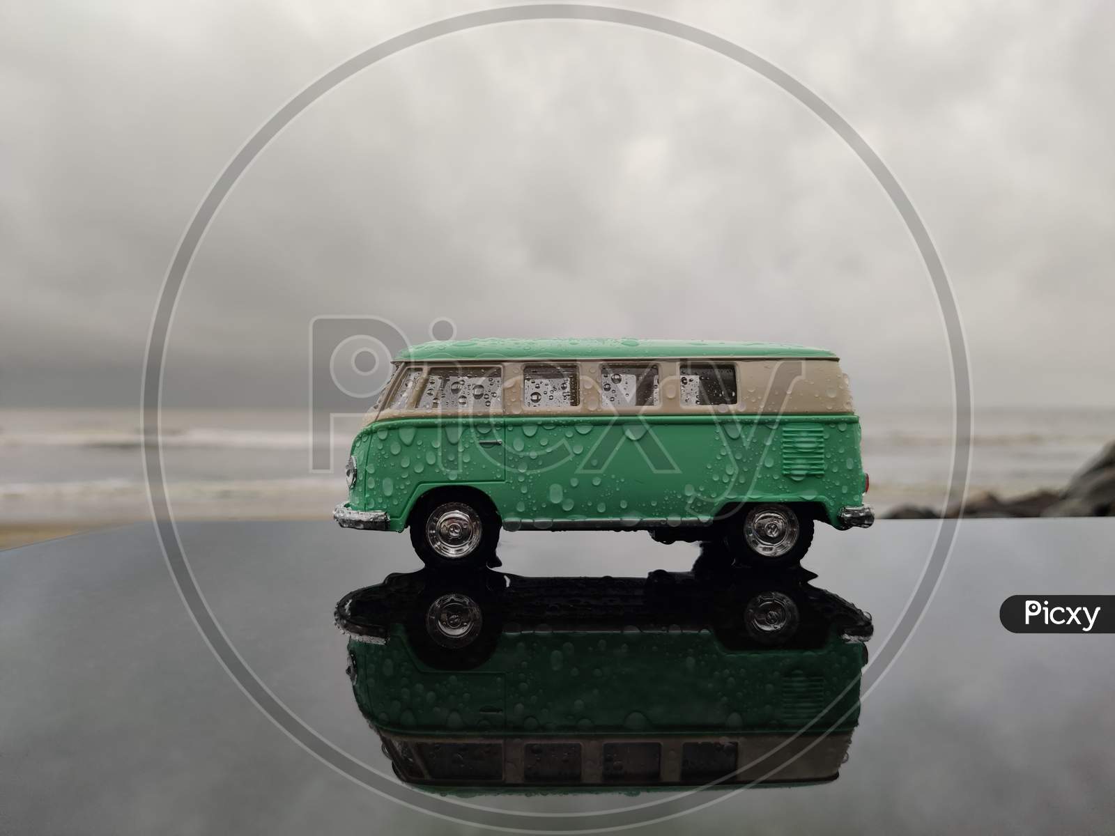 rainy moody image of vintage toy van with beach background
