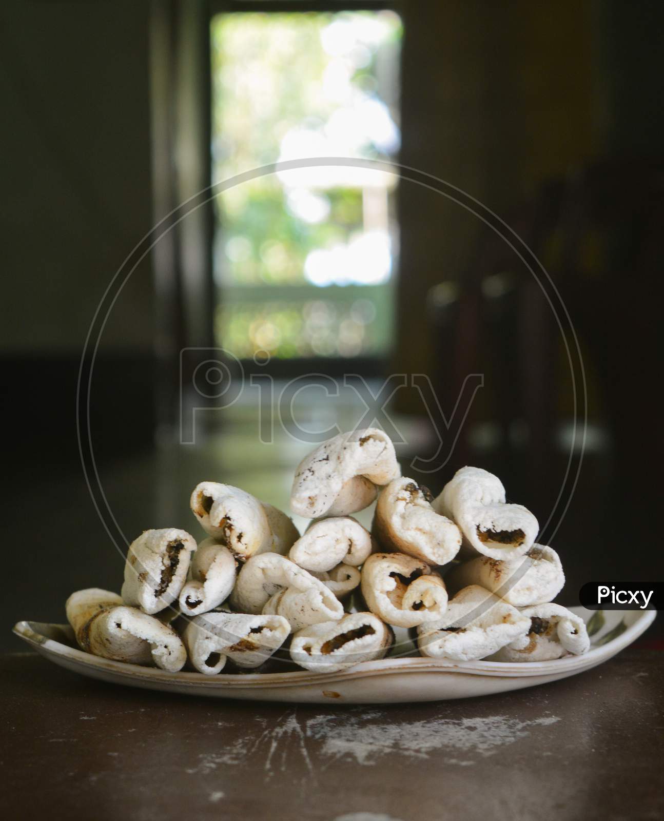A Traditional food (sweet) of Assam. TIL PITHA, which is made with cocunut or TIL and rice.