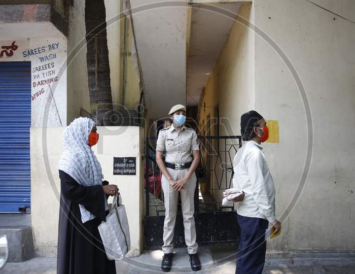 A police woman stands guard as food is distributed in a poor neighbourhood during the nationwide lockdown to stop the spread of Coronavirus (COVID-19) in Bangalore, India, May 02, 2020.